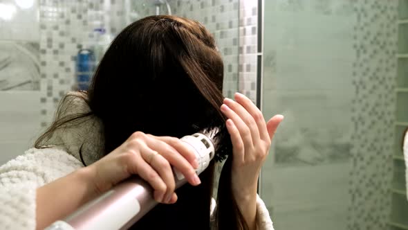 Woman with Hairdryer in Front of Mirror