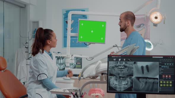 Dentist and Assistant Looking at Green Screen on Monitor