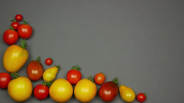 Grey Background with Colorful Tomatoes in the Corner. Stop Motion