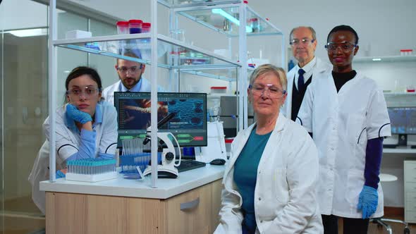 Team of Multiethnic Scientists Sitting in Laboratory Looking at Camera
