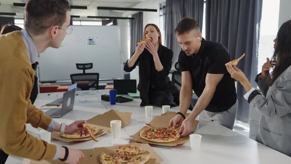 Colleagues Eat Pizza During Lunch in the Office