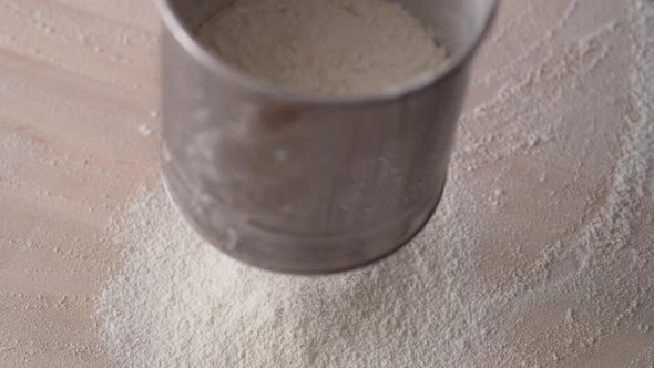 Camera follows sifting flour. Slow Motion.