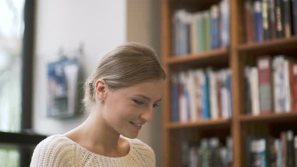 Woman Smiles While Typing On Laptop