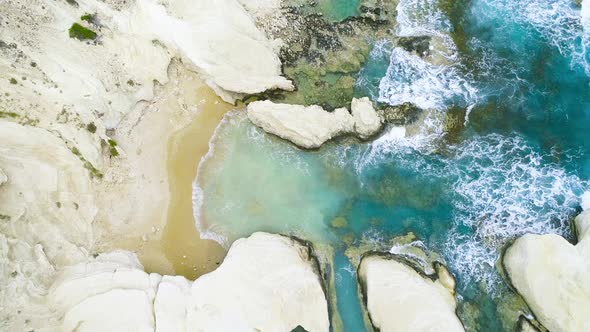 Aerial Top View of Waves Break on Rocks in a Blue Ocean Sea Waves on Beautiful Beach Aerial Drone