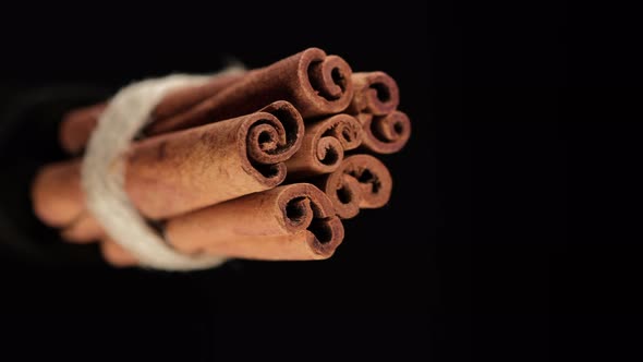 Cinnamon sticks on black background. Vertical video. 4K UHD video