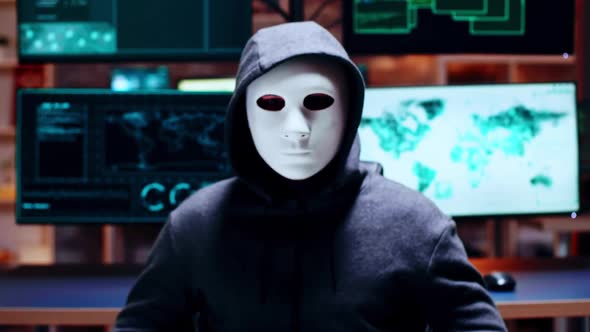 Zoom in Shot Cyber Criminal Wearing a White Mask