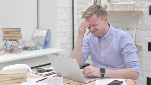 Businessman Feeling Headache While Working on Laptop