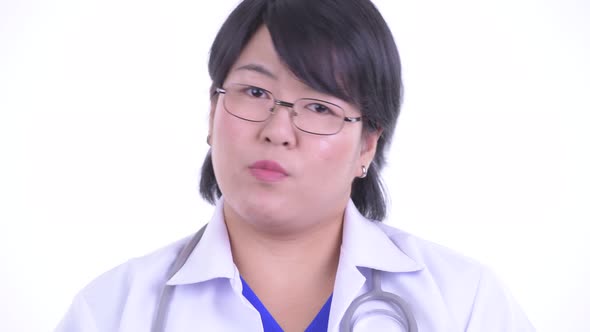 Face of Serious Overweight Asian Woman Doctor Nodding Head No