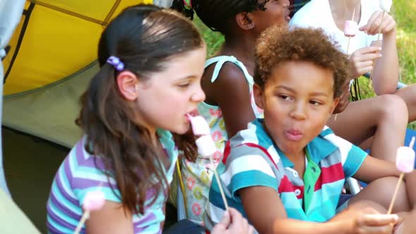 Kids having marshmallow candy in tent