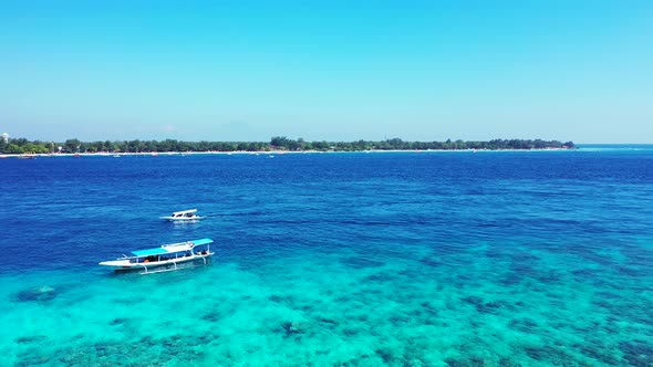 Touring boats floating on beautiful blue azure sea with rocky bottom seen through clear water around