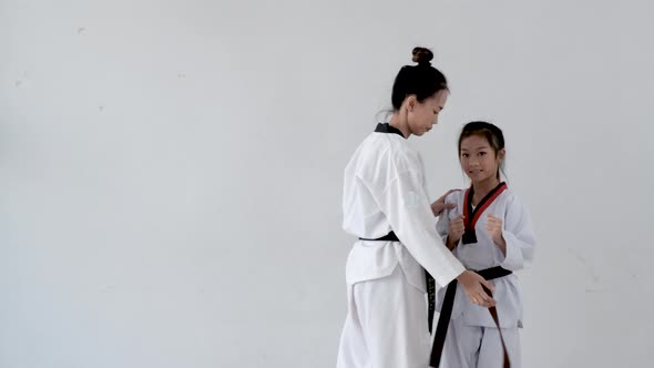 Young Taekwondo coach teach her student how to keep right action and posture in gym