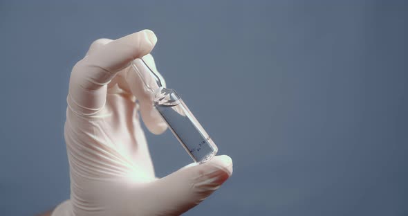 A Hand in a Medical Glove Holds and Shows the Ampoule