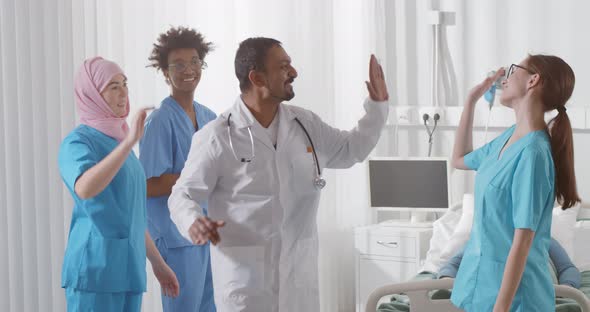 Multiethnic Medical Team Giving High Five in Hospital Ward