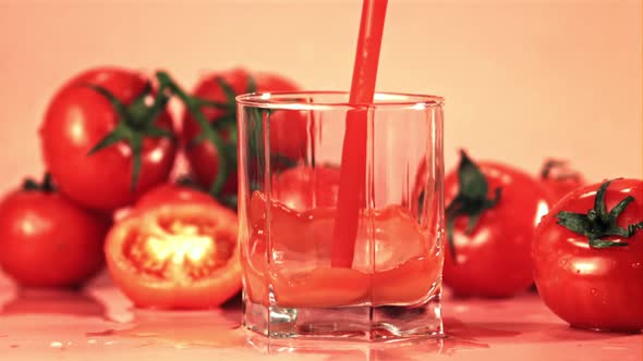 Super Slow Motion Jet Tomato Juice Pours Into a Glass with Spray