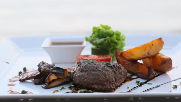 Filet Mignon Beef Steak on Beach Table in Luxury Resort Outdoors Restaurant