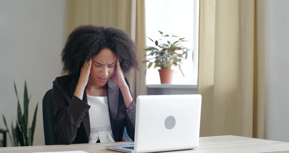 African Woman Typing Report Checks Email on Laptop, Having Headache Painful Condition, Feeling