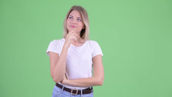 Happy Young Beautiful Blonde Woman Thinking and Looking Up