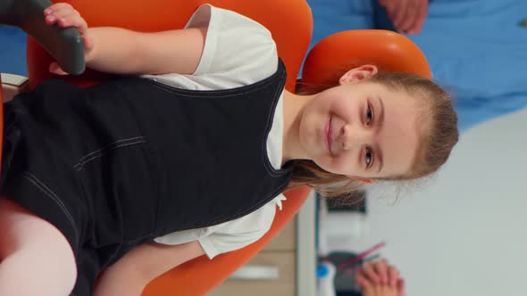 Vertical Video Portrait of Little Girl Patient Looking at Camera Waiting for Pediatric Stomatologist