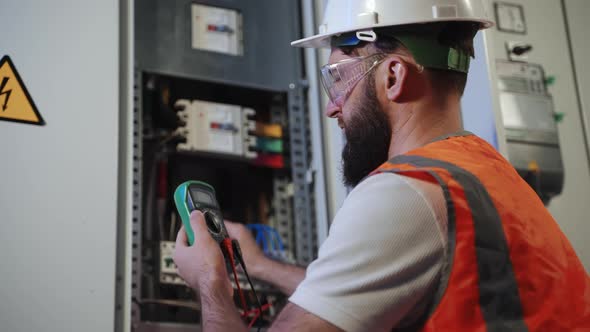 Work Under Voltage Electrician is Checking Serviceability of Equipment