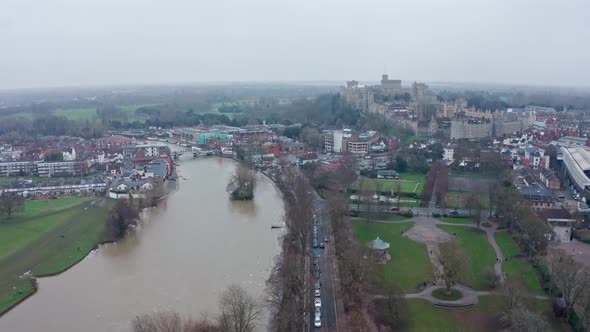 cinematic rotating aerial drone shot of thames river connecting Eton and Windsor