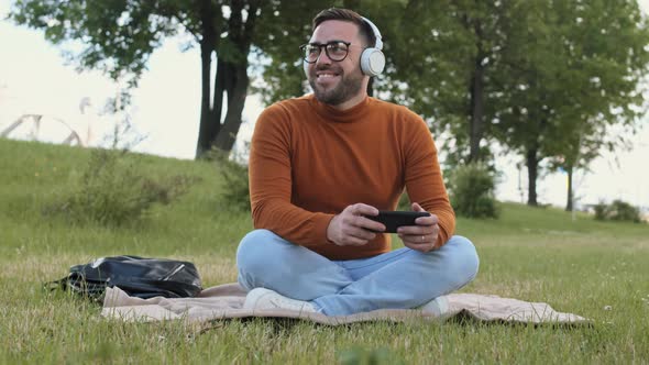 Caucasian Man in Headphones on Lawn