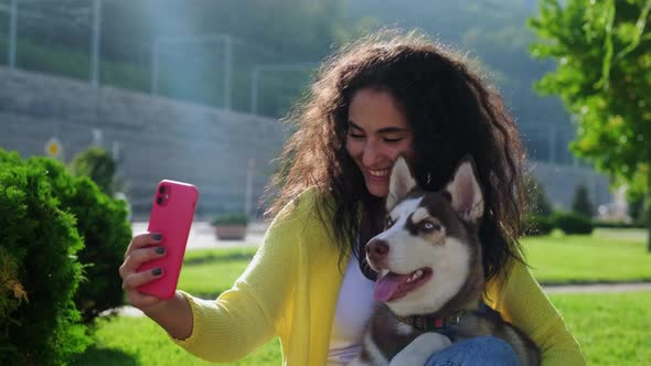 Brunette Woman and Her Cute Husky Dog are Photographing Together By Phone