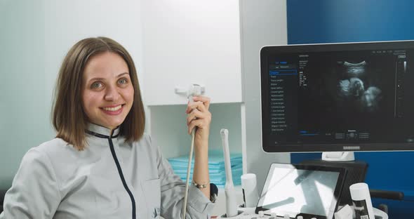 Close Up Portrait of Professional Smiling Young Woman Doctor Sonographer Sitting