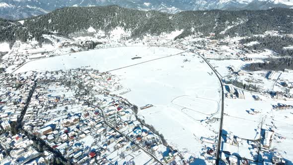 Aerial view of snow covered Bakuriani with beautiful snowy mountains around. Georgia 2021