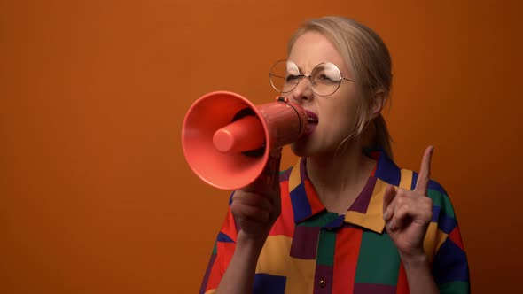 Style blonde in 90s shirt with megaphone on orange background