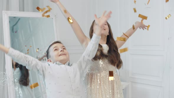 Portrait of Happy Children Throwing Golden Confetti Into Camera.