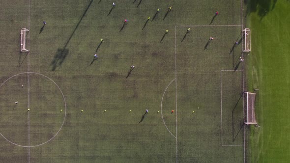 Top View of a Drone Taking Aerial Shots of Kids Playing Soccer on a Soccer Field