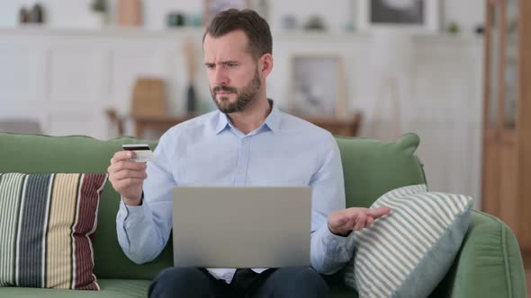 Online Shopping Failure on Laptop for Young Man on Sofa