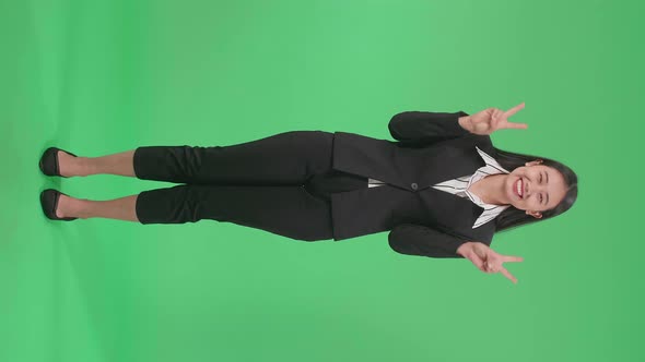 Full Body Of Asian Business Woman Showing Gesture Peace And Smiling While Standing On Green Screen