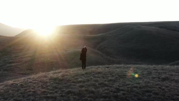 The Boy Starring Hand Toward Sunlight Stands on the Top of the Hill Glare and the Rays