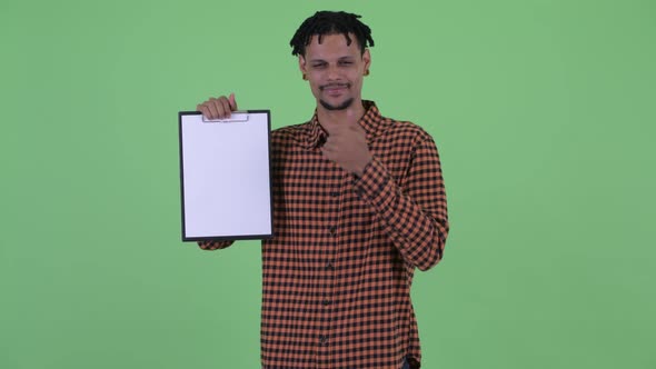 Happy Young Handsome African Man Showing Clipboard and Giving Thumbs Up