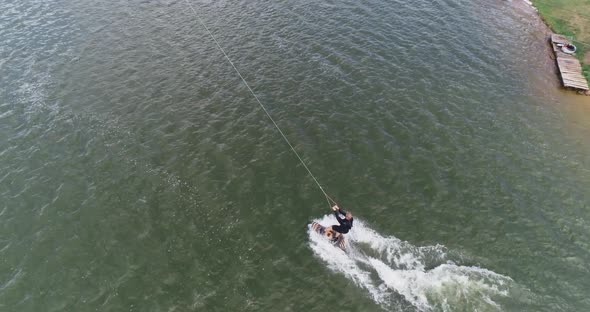 Wakeboarding, the Sportsman Surfs on the Water, Ride on a Wakeboarding Board and Performs Tricks