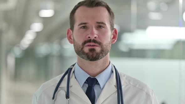 Portrait of Friendly Male Doctor Talking on Video Call