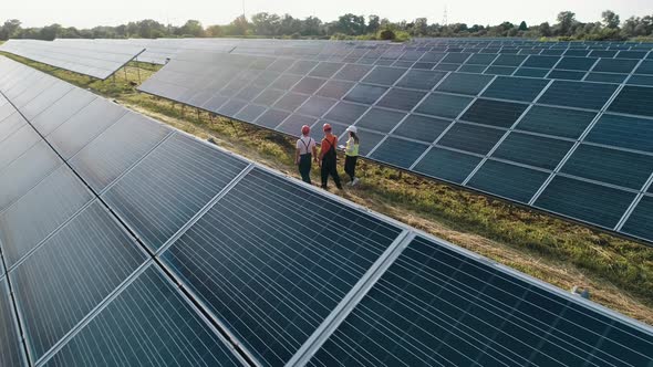 Top View of Specialists Walking Across a Solar Power Plant