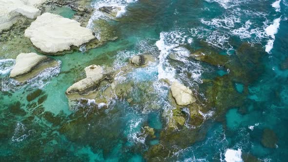 Aerial Top View  Footage By Drone of Ocean Blue Waves Break on High Cliff of a Rocky Mountain