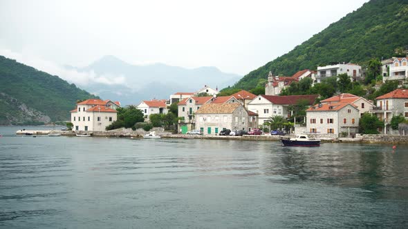 View From the Ferry to the Houses on the Coast Against the Backdrop of Mountains