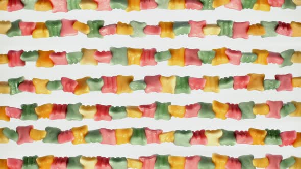 Lot of watered multi-colored sweets, juicy colored chewing marmalade rotates on white background