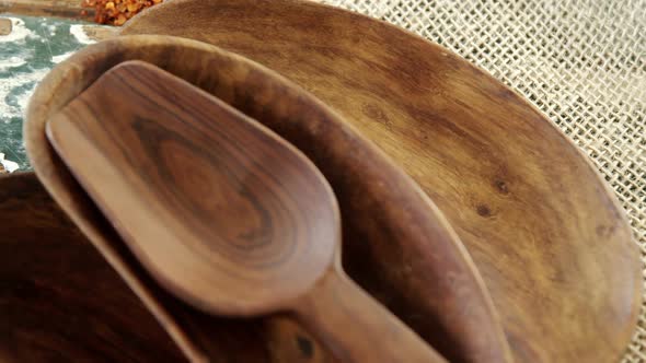 Empty wooden bowl with crushed red pepper on sack