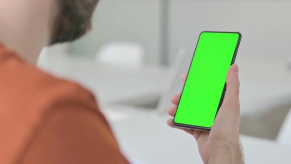 Young Man Using Smartphone with Green Chroma Key Screen