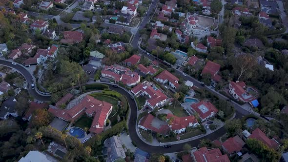 Aerial panning down on luxurious mansions in Los Angeles California where wealthy people live.