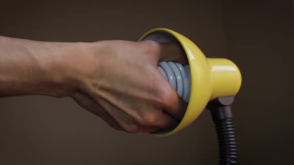 Close up of a hand taking a light bulb of a yellow lamp