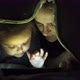 Little girl and her mother using tablet under the blanket. Close-up. - VideoHive Item for Sale