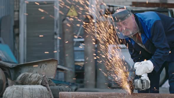 Worker Cutting Metal Pipe