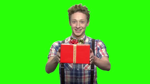 Handsome Teen Boy in Fashionable Clothes Giving Gift Box