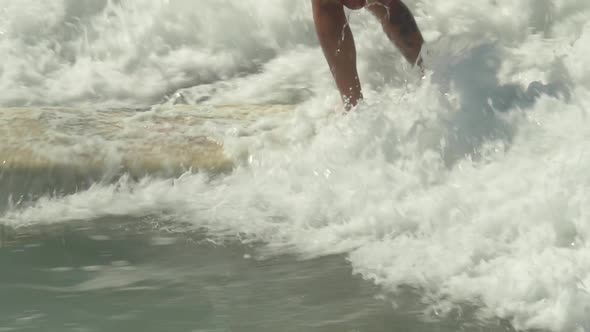 A male surfer rides a wave on a longboard surfboard.