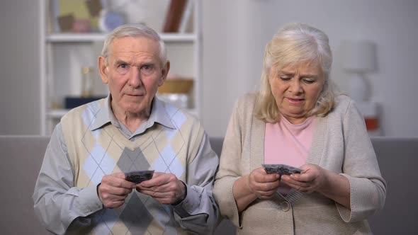 Upset Senior Couple Holding Euro Banknotes, Suffering From Poverty Problems